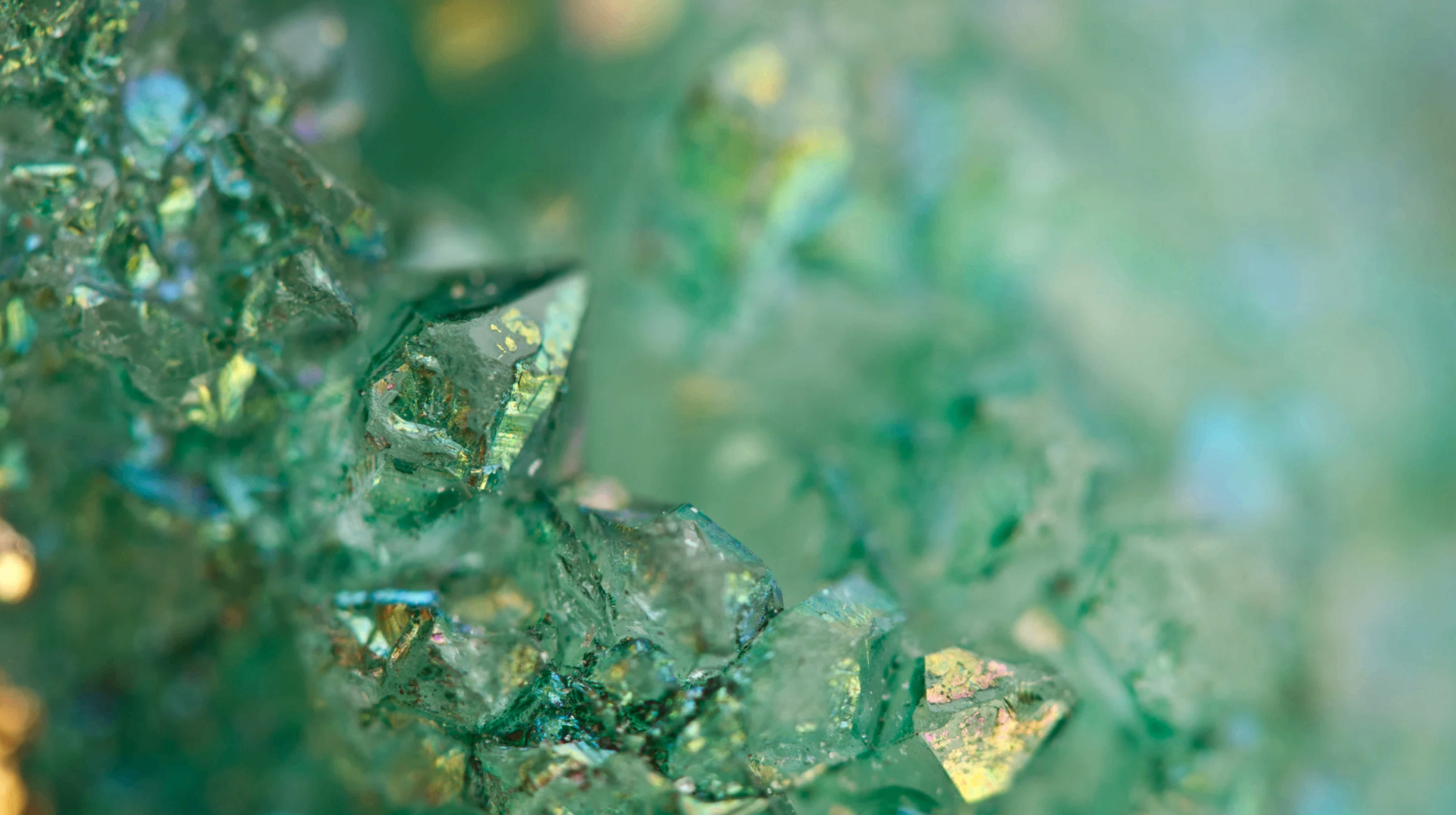 Emerald crystal cluster catching iridescent gold light