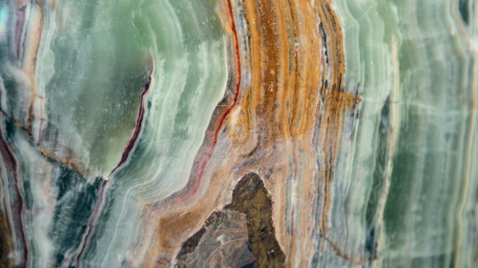 Cross-section of variegated agate — bands of green, ochre and cream